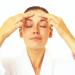 Woman giving herself a facial massage to help stimulate collagen production in the face naturally
