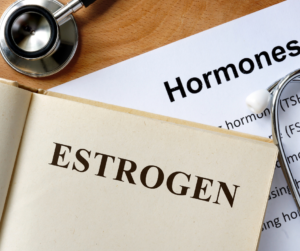 Estrogen book, stethoscope and hormone page with definition